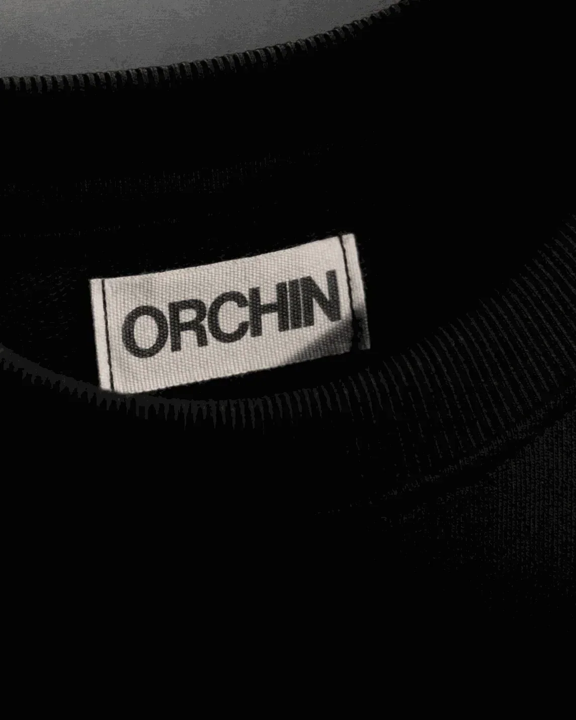 Black cotton terry The Unusual Tee with hand embroidery and organic cotton twill patch.	