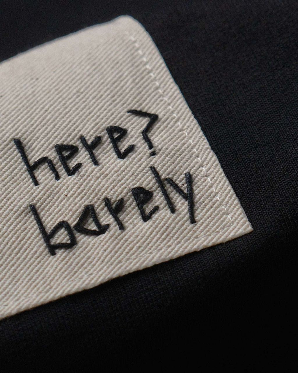 Black cotton terry The Barely Tee with hand embroidery and organic cotton twill patch.	